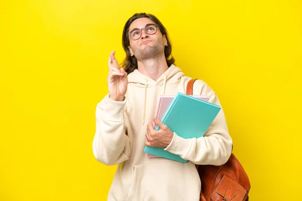 Νεαρός Μαθητής Όμορφος Άντρας Απομονωμένος Κίτρινο Φόντο Δάχτυλα Σταυρωμένα Και — Φωτογραφία Αρχείου