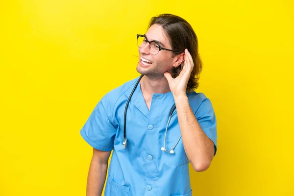 Young Surgeon Caucasian Man Isolated Yellow Background Listening Something Putting — Stockfoto