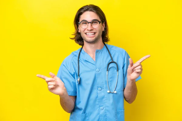 Young Surgeon Caucasian Man Isolated Yellow Background Pointing Finger Laterals — Stock Photo, Image