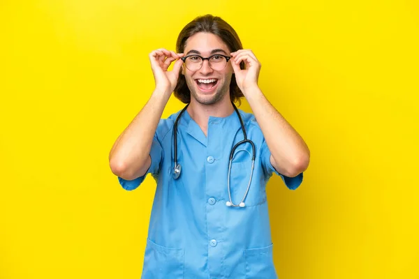 Joven Cirujano Caucásico Aislado Sobre Fondo Amarillo Con Gafas Sorprendido — Foto de Stock