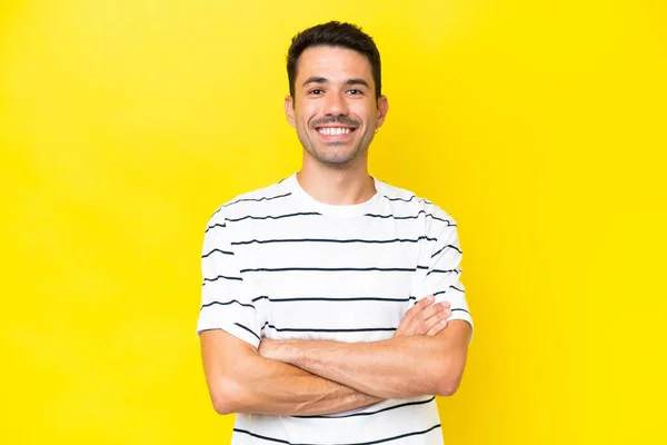 Mladý Pohledný Muž Nad Izolovaným Žlutým Pozadím Který Drží Paže — Stock fotografie