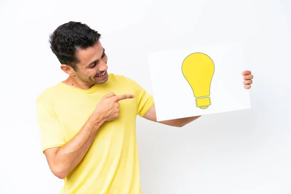 Young Handsome Man Isolated White Background Holding Placard Bulb Icon — Stock Photo, Image