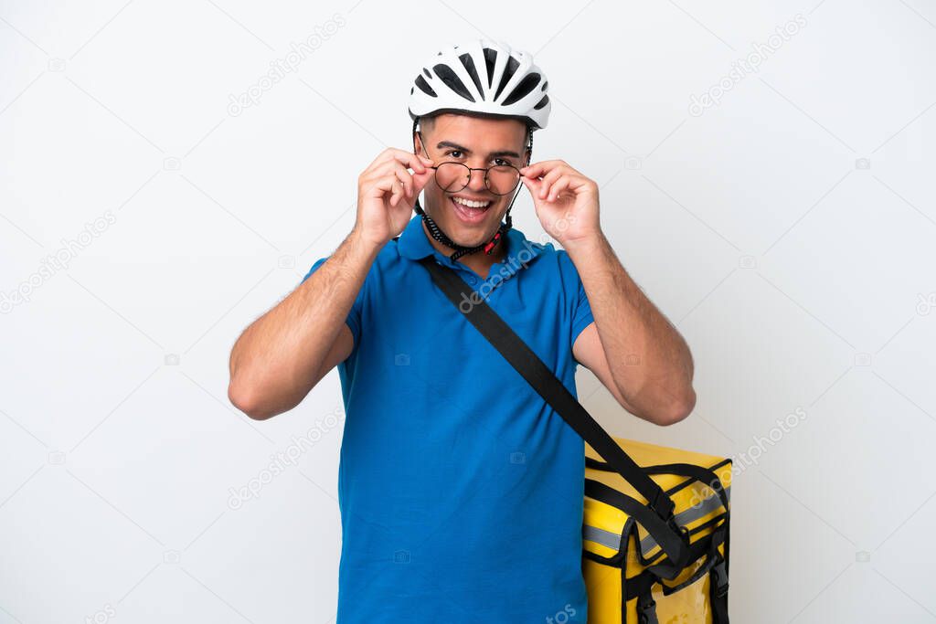 Young caucasian man with thermal backpack isolated on white background with glasses and surprised