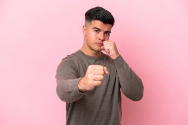 Beyaz tenli yakışıklı bir adam pembe arka planda izole edilmiş.