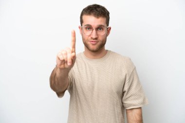 Beyaz arka planda izole edilmiş beyaz tenli genç adam ciddi bir ifadeye sahip birini sayıyor.