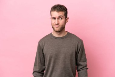 Pembe arka planda izole edilmiş genç beyaz bir adam.