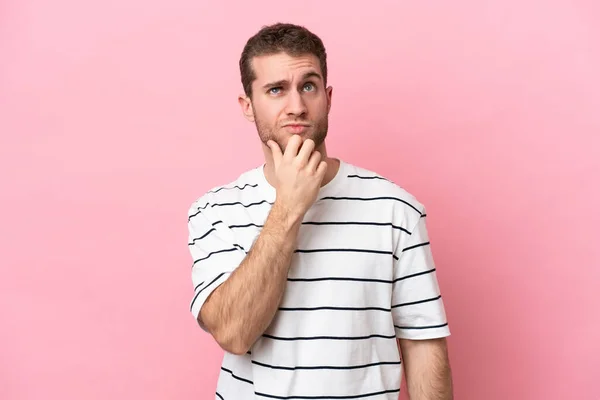 Joven Hombre Caucásico Aislado Sobre Fondo Rosa Teniendo Dudas — Foto de Stock