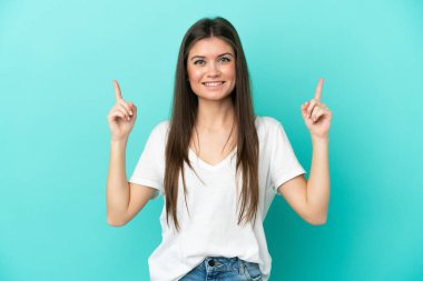 Mavi arka planda izole edilmiş beyaz bir kadın harika bir fikre işaret ediyor.