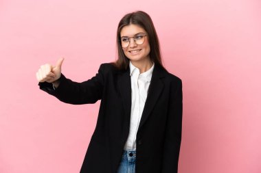 Pembe arka planda izole edilmiş genç beyaz kadın iyi niyet gösterisi yapıyor.