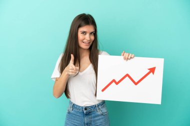 Mavi arka planda izole edilmiş genç beyaz bir kadın elinde büyüyen bir istatistik okunun sembolü olan ve ön tarafı işaret eden bir tabela tutuyor.