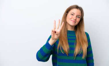 Beyaz arka planda izole edilmiş beyaz kadın mutlu ve parmaklarıyla üçe kadar sayıyor.