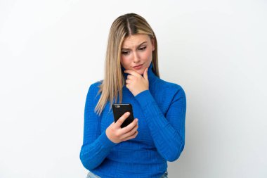 Beyaz arka planda izole edilmiş genç beyaz kadın düşünüp bir mesaj gönderiyor.