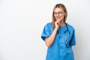 Genç cerrah kadın izole edilmiş beyaz arka planda yan tarafa bakıyor ve gülümsüyor.