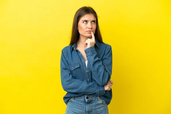 Mujer Joven Caucásica Aislada Sobre Fondo Amarillo Que Tiene Dudas — Foto de Stock