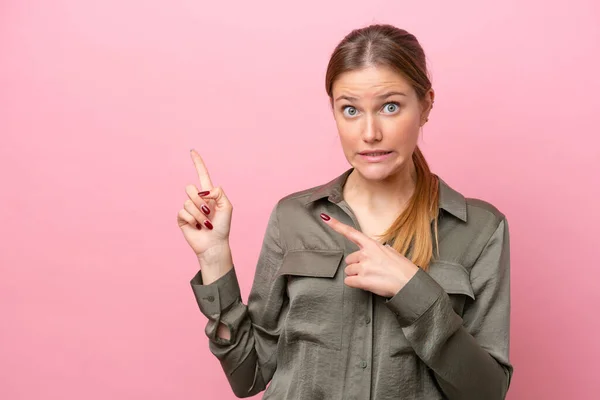 Mujer Joven Caucásica Aislada Sobre Fondo Rosa Asustada Señalando Hacia — Foto de Stock