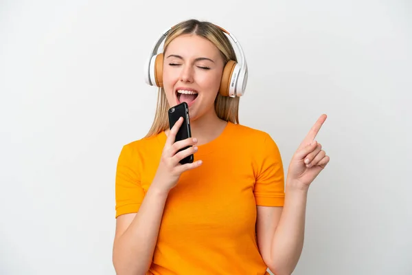 Νεαρή Καυκάσια Γυναίκα Απομονωμένη Λευκό Φόντο Ακούγοντας Μουσική Κινητό Και — Φωτογραφία Αρχείου