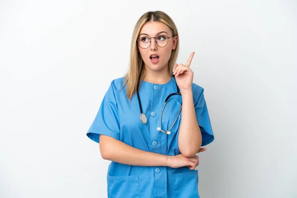 若い外科医の女性は白い背景に隔離され指を指差すアイデアを考え — ストック写真