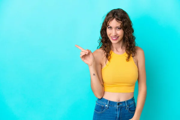 Young Woman Curly Hair Isolated Blue Background Pointing Side Present — Φωτογραφία Αρχείου