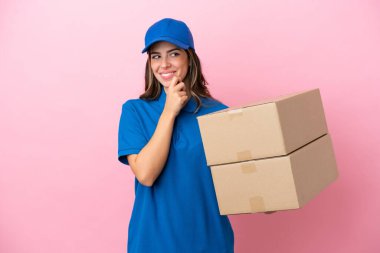 Pembe arka planda izole edilmiş bir İtalyan kadın. Yana bakıyor ve gülümsüyor.