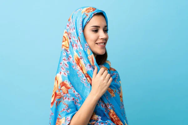 Young Moroccan woman with traditional costume isolated on blue background