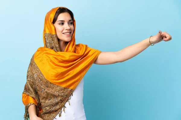 年轻的摩洛哥女人 穿着传统服装 蓝色背景 带着大拇指举手表决 — 图库照片