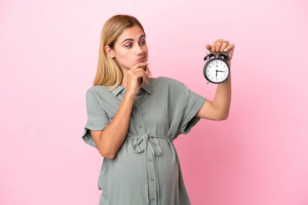 Mujer Uruguaya Joven Aislada Sobre Fondo Azul Embarazada Sosteniendo Reloj — Foto de Stock