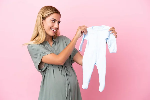 Giovane Donna Uruguaiana Isolata Sfondo Blu Incinta Con Mano Vestiti — Foto Stock