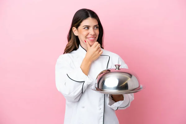 분홍색 배경에 뚜껑을 쟁반을 이탈리아의 요리사 바라보며 — 스톡 사진