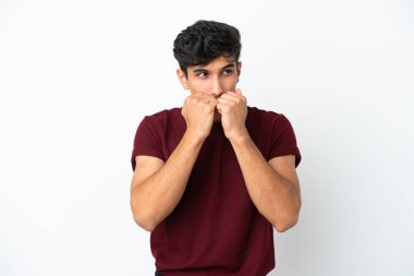 Beyaz arka planda izole edilmiş genç Arjantinli adam gergin ve korkmuş bir şekilde elleriyle suni teneffüs yapıyor.