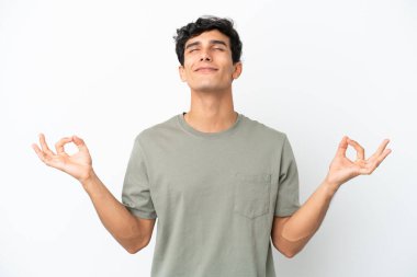 Young Argentinian man isolated on white background in zen pose