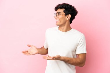 Arjantinli genç bir adam pembe arka planda izole edildi.