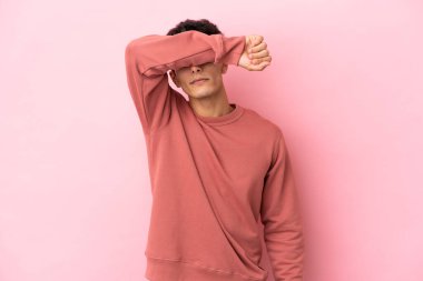 Arjantinli genç adam pembe arka planda izole edilmiş gözleri elleriyle kaplayan