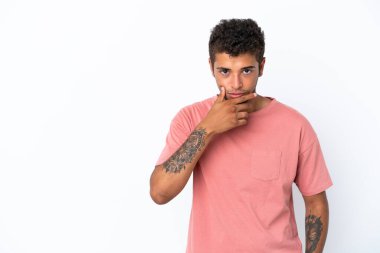 Genç yakışıklı Brezilyalı adam beyaz arka planda soyutlanmış düşünüyor.