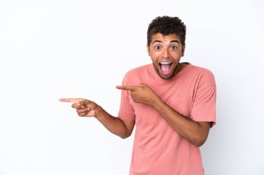 Beyaz arka planda izole edilmiş yakışıklı Brezilyalı adam şaşırmış ve işaret ediyor.