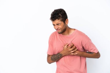 Genç ve yakışıklı Brezilyalı bir adam, beyaz arka planda soyutlanmış, kalbinde bir ağrı var.