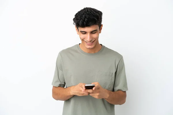 Молодой Аргентинский Мужчина Белом Фоне Отправляет Сообщение Мобильным Телефоном — стоковое фото