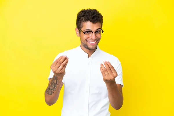 Молодий Вродливий Бразильський Чоловік Ізольований Жовтим Фоном Робить Гроші Жестом — стокове фото