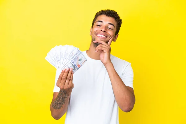 Jonge Braziliaanse Man Neemt Veel Geld Geïsoleerd Gele Achtergrond Denken — Stockfoto