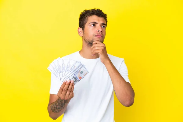 Jonge Braziliaanse Man Neemt Veel Geld Geïsoleerd Gele Achtergrond Kijkt — Stockfoto