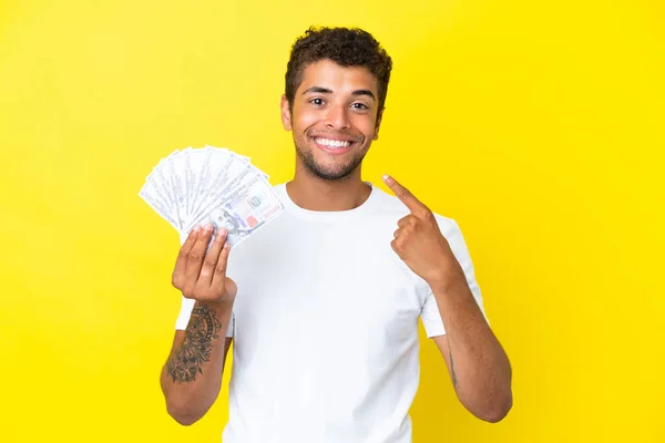 Jonge Braziliaanse Man Neemt Veel Geld Geïsoleerd Gele Achtergrond Geven — Stockfoto