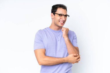 Beyaz arka planda, dirsek ağrısı çeken genç beyaz bir adam.