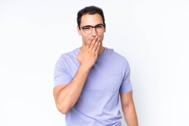 Beyaz arka planda izole edilmiş genç beyaz adam mutlu ve gülümsüyor.