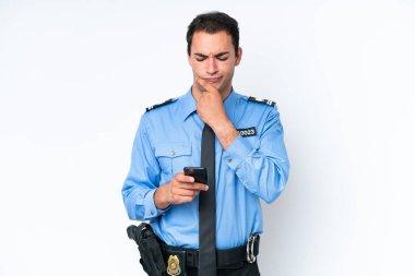 Beyaz arka planda izole edilmiş genç bir beyaz adam düşünüyor ve bir mesaj gönderiyor.