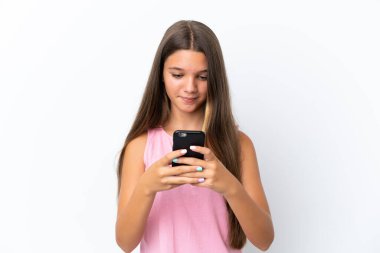 Beyaz arka planda izole edilmiş küçük beyaz kız cep telefonuyla bir mesaj gönderiyor.