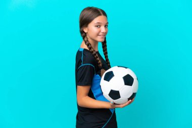 Mavi arka planda, futbol topuyla izole edilmiş küçük beyaz kız.
