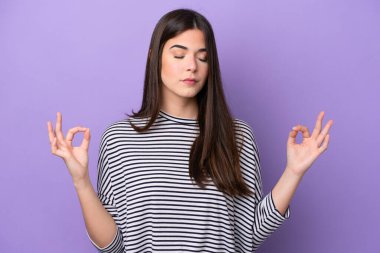 Mor arka planda Zen pozisyonunda izole edilmiş genç Brezilyalı kadın