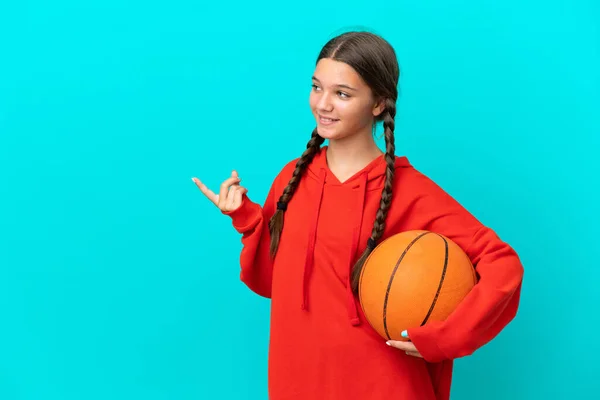 Niña Caucásica Jugando Baloncesto Aislada Sobre Fondo Azul Apuntando Con —  Fotos de Stock