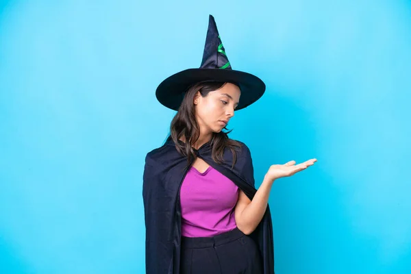 Mladá Hispánka Oblečená Jako Čarodějnice Izolovaném Pozadí Držení Copyspace Pochybnostmi — Stock fotografie