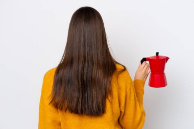 Arka planda beyaz arka planda kahve demliği tutan genç Brezilyalı kadın.