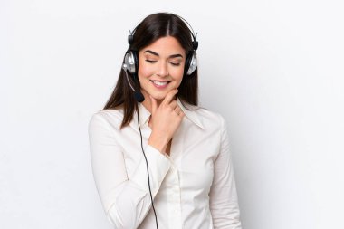 Beyaz arka planda izole edilmiş bir kulaklıkla çalışan beyaz pazarlamacı kadın yan tarafa bakıyor.